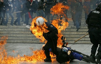 A policeman is seen in flames as he trie